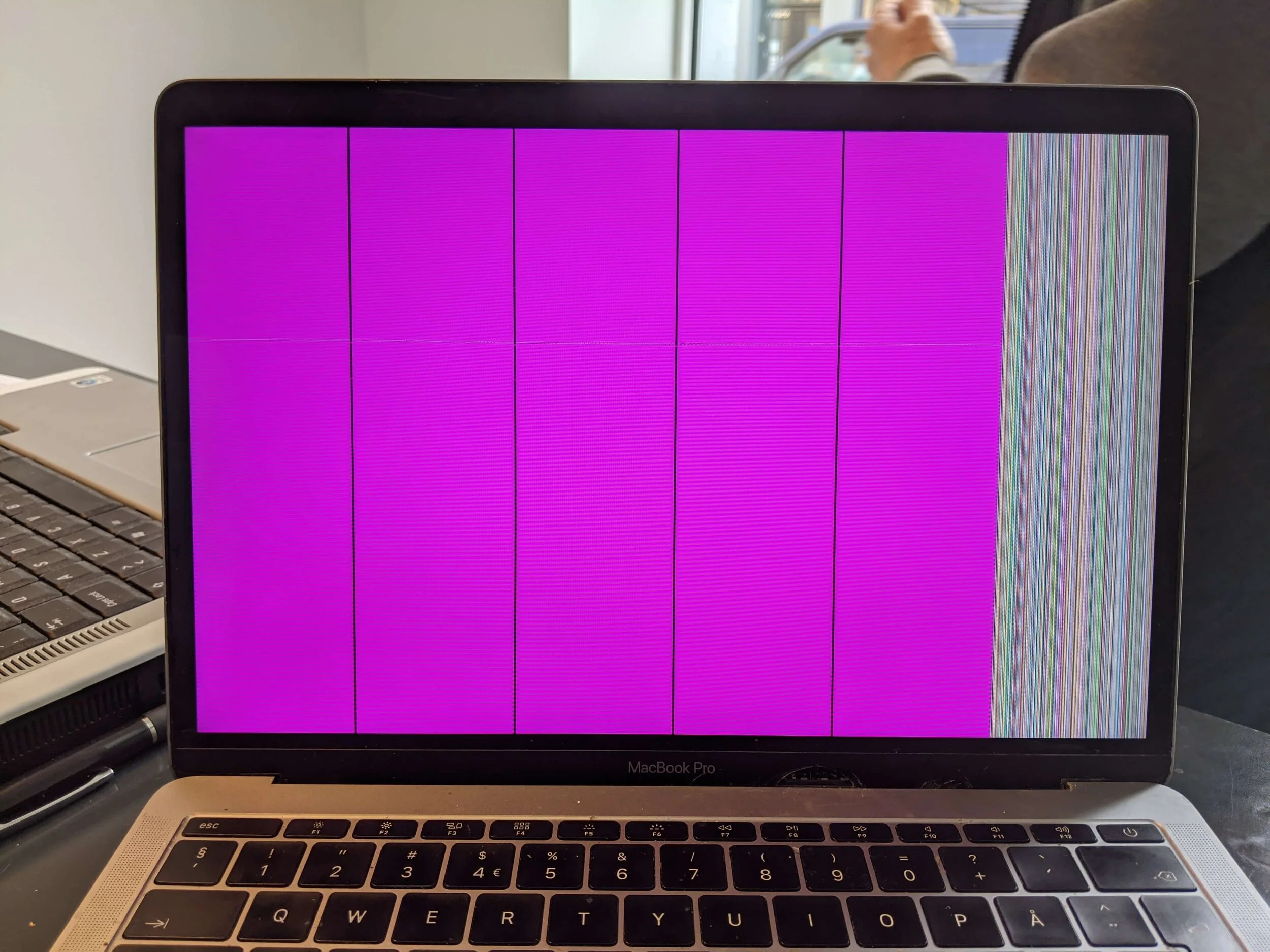 Laptop-skjerm med fargefelt og vertikale linjer